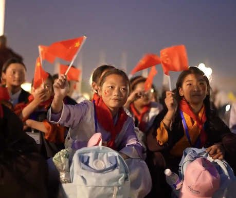 སྤྱི་ཟླ་5པའི་ཚེས་19ནས་25ཉིན་བར། གུང་གཞོན་ཚོགས་པ་སྡེ་དགེ་རྫོང་ཨུས་སྡེ་དགེའི་ན་གཞོན་ལོ་ཆུང་26སྒྲིག་འཛུགས་བྱས་ཏེ་པེ་ཅིན་དུ་བསྐྱོད་ནས“ཀྲེ་ལི་ཐེན་ཧྥུ་སེའུ་འབྲུ་དམར”ཞེས་པའི་མི་རིགས་འགྲོ་འོང་དང་སྤེལ་རེས། མཉམ་འདྲེས་བཅས་ཀྱི་བྱེད་སྒོ་སྤེལ་བ་རེད། འདི་ནི་གནམ་བདེ་སྒོ་མོ་ཆེའི་ཐང་ཆེན་དུ་རྒྱལ་དར་སྒྲེང་པའི་མཛད་སྒོ་ལ་ལྟ་བ། 5月19日至25日，共青团德格县委员会组织26名德格青少年代表赴北京开展“浙里天府石榴红”民族交往交流交融活动。视频为同学们在天安门广场观看升旗仪式。